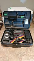 Sony Betamovie video camera with strap and cables inside a hard plastic carrying case shown open, camera and accessories are organized in molded compartments.