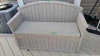 Front view of the Suncast resin garden bench outdoors showing its overall condition and design features including armrests and contoured backrest.