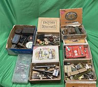 Photo of the full assortment of hardware parts in multiple boxes on green cloth background.