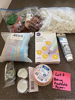 Baking decorating tips, icing tube, various paper and silicone cupcake liners, and miscellaneous decorating supplies in plastic bags.
