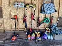Overview of five garden power tools hung on workshop wall
