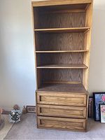 Full view of the wooden dresser and hutch showing three drawers at the bottom and four shelves above.