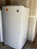 Exterior front view of white upright freezer showing Whirlpool logo and overall condition
