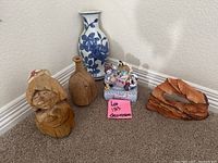 Full view of lot with music box, wooden carvings, and vase