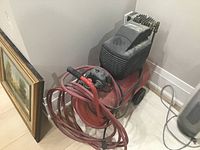 Photo of Jet 25/205 air compressor showing red tank, black motor and control unit with attached hoses.