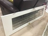 White French door laid flat showing bevelled glass with decorative metal grid inserts, door frame, and attached hardware.