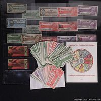 Image showing various Canadian Tire Money bills in different denominations and colors laid out with the numismatic catalogue in view.