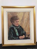 Full view of oil on canvas painting of a lady sitting in a chair, framed in a gold-colored frame with cream mat.
