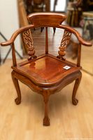 Front view of the Chinese intricately carved rosewood corner chair showing detailed back and armrest design.