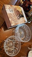 Two cut crystal bowls displayed on table with box for larger bowl.