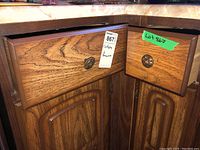 Two wooden drawers with round metal pulls, showing lot labels