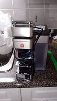 Front view of the FrancisFrancis for Illy espresso maker showing frother attachment and illy branding.