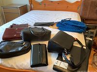 Overview photo of 10 items on bed including handbags, crochet bags, wallets, portfolio