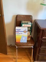 Both original boxed heating items displayed on a chair: Equate king size heating pad and Sunbeam cuddle up heated throw.