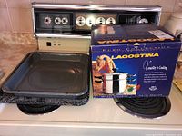 Lagostina box and two roasting pans on stove top