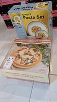 Photo shows boxed 5-piece pasta set featuring plates with a decorative fruit pattern, visible on the packaging.