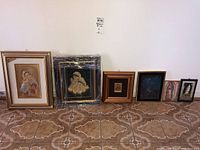 Photo of all six religious prints arranged on floor, showing variety of frame sizes and artwork styles.