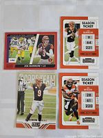 Four football cards with Joe Burrow and Joe Mixon in protective sleeves on white surface, showing front faces clearly