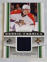 Full front view of Jonathan Huberdeau rookie jersey card with visible dark blue jersey fabric swatch and team logo
