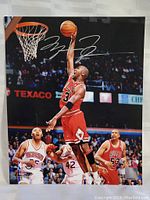 Photo of signed Michael Jordan 8x10 basketball photo showing Jordan jumping near hoop mid-air with signature above