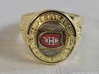 Front and angled view of the Montreal Canadiens Stanley Cup Championship Ring showing the logo and engraved text.