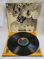 Vinyl record with multicolor Capitol label on the black LP disc, partially pulled out of inner sleeve.