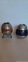 Two vintage Argentine yerba mate gourds side by side with Alpaca silver detailing and leather accents