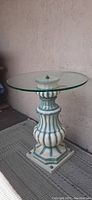 Full view of the Belgian post modern plant stand/table showing bulbous sculptural base and round glass top.