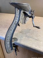 Side view of vintage cast iron cherry stoner/pitter showing embossed text 'ENTERPRISE MFG CO PHILA PA'
