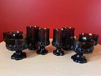 Front view of 8-piece set showing 4 goblets and 4 dessert bowls arranged in front of a red background.