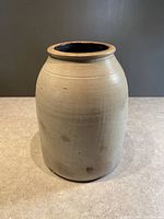 Front view of primitive stoneware crock container showing beehive shape and beige surface.
