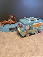 Scooby Doo soap dish with Scooby figure and Mystery Machine toothbrush holder side by side on a surface.