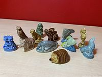 Twelve Wade Whimsies animal porcelain figurines displayed on red surface, showing variety of animals and colors.