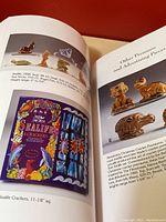 Open pages of the Wade Miniatures Book showing color photos and descriptions of miniature figurines and promotional Wade pieces, with a colorful label of Sea Life Crackers on one page.