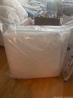 White duvet compressed and sealed in clear plastic packaging, showing bulk and softness.