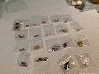 Overview of all 20 pairs of earrings including pierced and clip-on styles, displayed in small clear plastic bags.