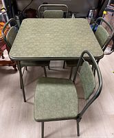 Full view of vintage Cosco square folding table with four matching chairs around it, showing overall condition and style.