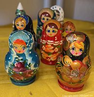 Hand painted Matryoshka nesting dolls arranged in a group, showing various colors and floral designs.
