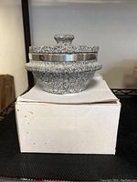 Single new Korean stone pot with lid on top of white box, showing stone texture and metallic band detail.