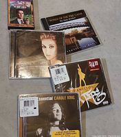 Photo showing all five items in lot with clear view of CD covers and cassette tape.