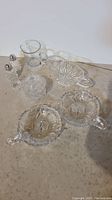 Full set of 8 crystal and heavy glass serving and kitchen items arranged on surface.