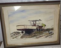 Framed watercolor painting of a lobster boat resting on dry land with grass, signed Dick VanNess.