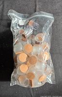 Clear plastic bag containing multiple transparent chair leg covers with attached tan felt pads on one end.
