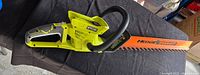 Full view of Ryobi cordless hedge trimmer showing blade, body, and handle