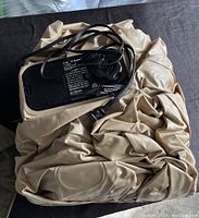 Full view of single beige air mattress with black electric pump on top, power cord visible