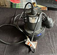 SimEr submersible sump pump showing overall appearance, power cord, and float switch on a black surface.