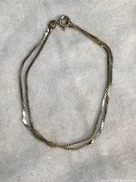 Photo showing the bracelet coiled with clasp visible to highlight the double serpentine design and clasp type.