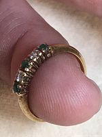 Close-up photo showing the 14kt gold band with alternating clear and green stones.