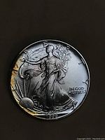 Front obverse side of 1992 Walking Liberty silver coin showing Lady Liberty walking with sun and inscriptions.