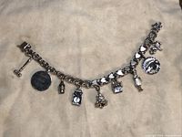 Full view of the charm bracelet showing all charms attached and the heart-shaped links on the chain.